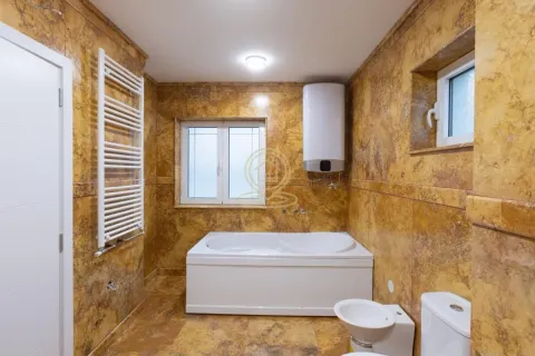 Bathroom tiled in yellow marble with a bathtub, water heater and sanitary ware. - image 22