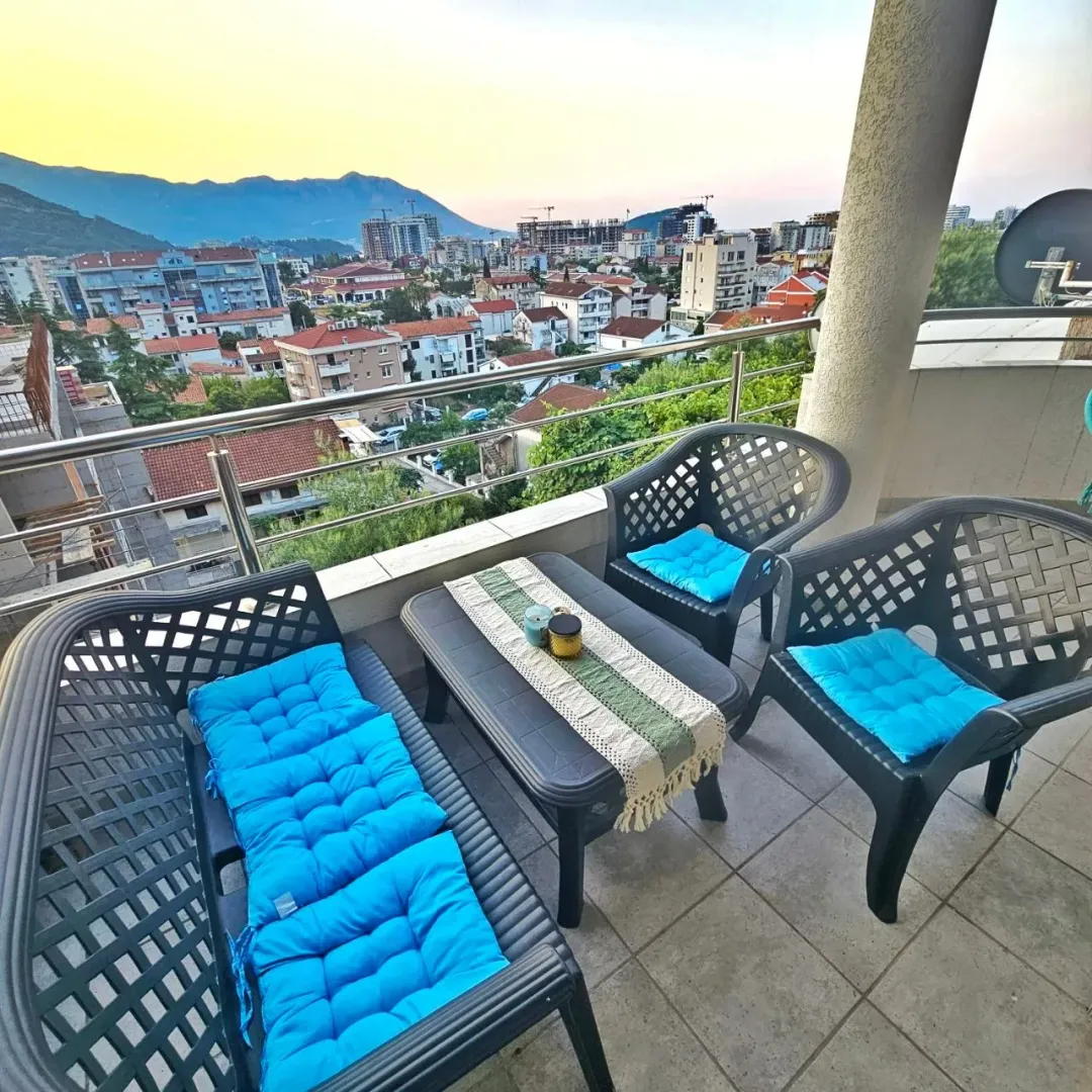 Furnished balcony with seating set and city view.