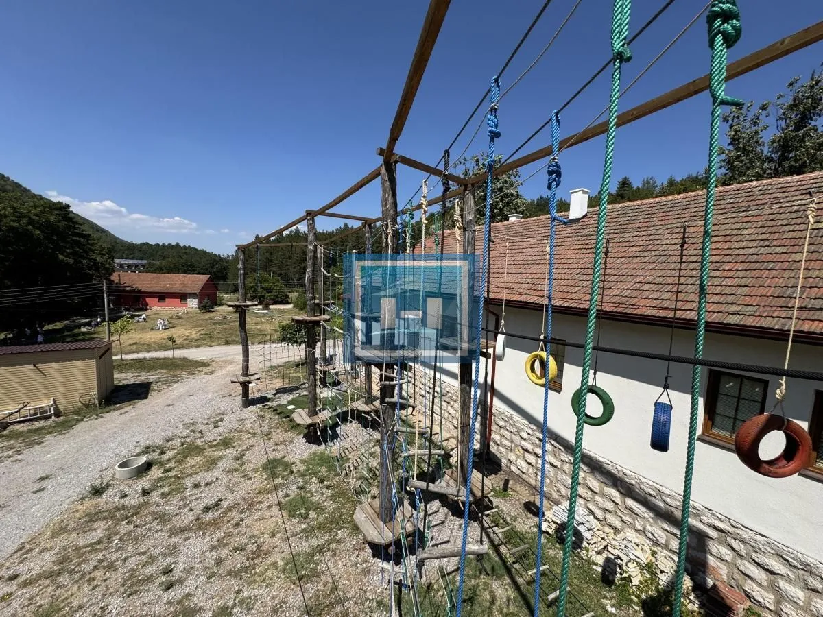 Yard with a wooden adventure playground next to the building.