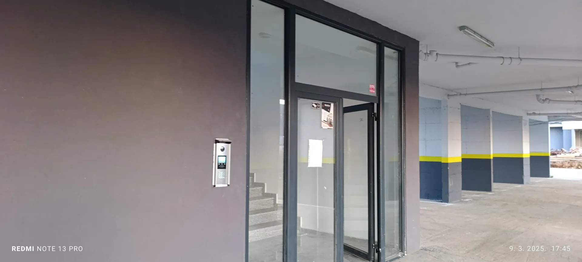 Entrance to a commercial space with glass doors and an intercom.