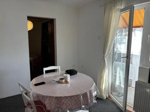 Trpezarijski sto sa stolicama u svetloj prostoriji sa izlazom na balkon. - image 7
