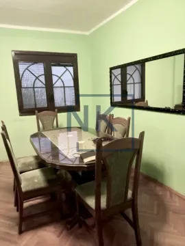 Dining area with a wooden table and chairs in a green room. - image 4