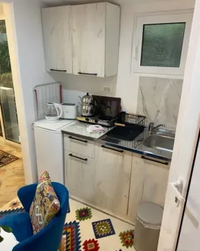Small kitchen with light-colored cabinetry and a sink. - image 8