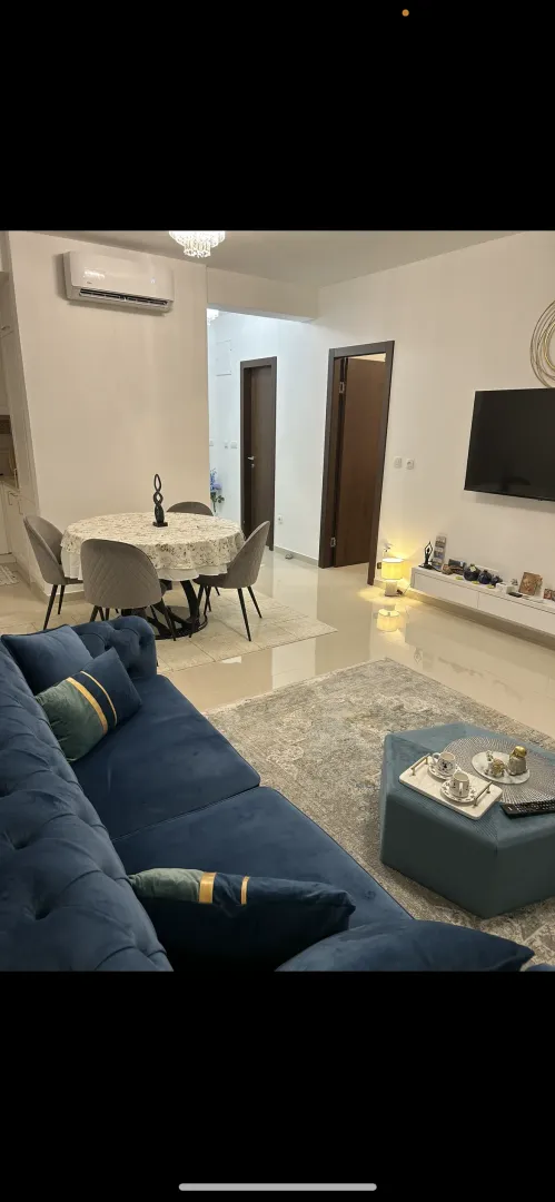 Dnevni boravak sa garniturom, trpezarijom i TV-om.