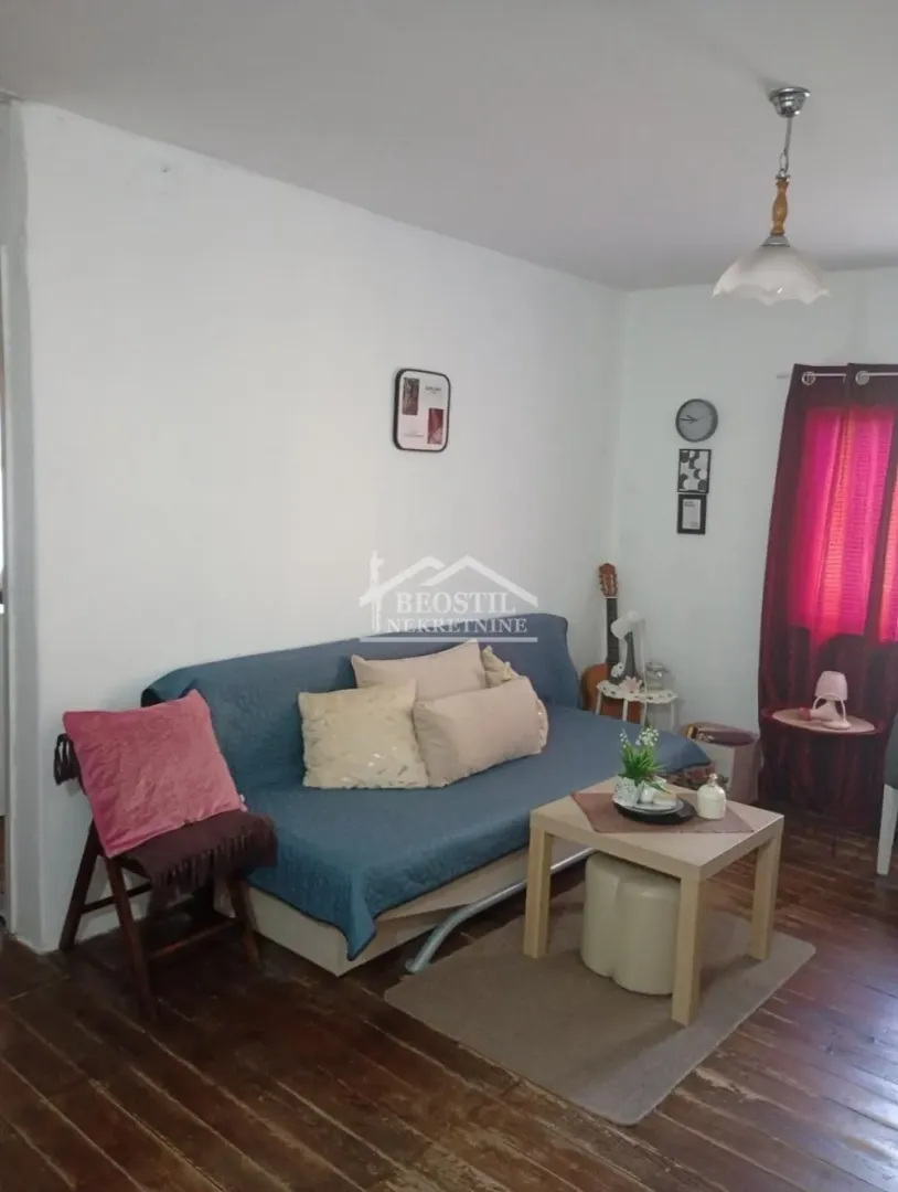 Living room with a blue sofa, coffee table, and wooden floor.