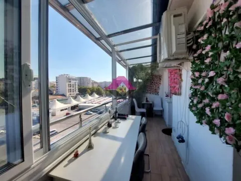 Zastakljeni balkon sa stolom, stolicama i dekorativnim cvećem. - image 9