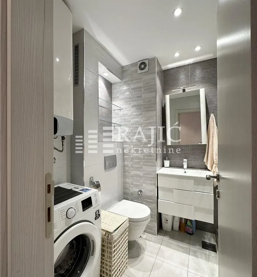 Modernly equipped bathroom with a washing machine.
