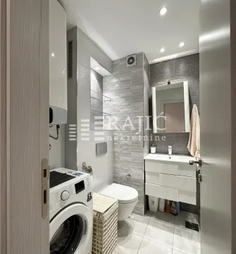 Modernly equipped bathroom with a washing machine. - image 10