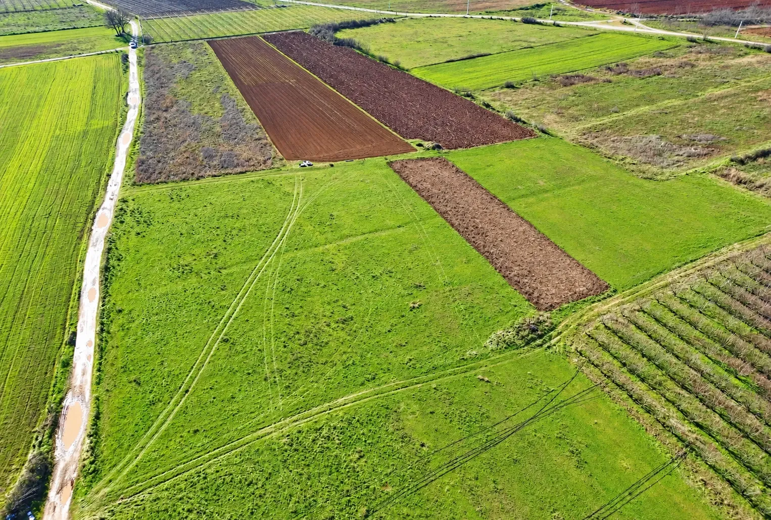 Pogled iz vazduha na poljoprivredno zemljište sa oranicama i livadama.