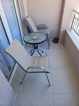 Manja natkrivena terasa opremljena baštenskim stolom i stolicama. - image 10