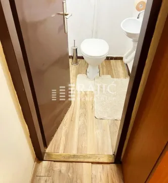 Pogled na manje kupatilo sa WC šoljom i umivaonikom. - image 11