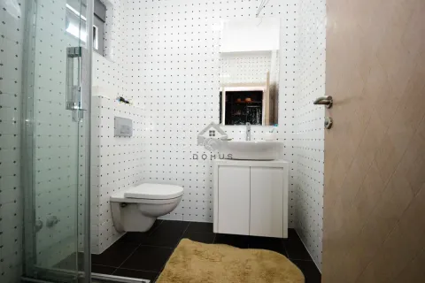 Small bathroom with a shower cabin, washbasin, and wall-hung toilet. - image 20