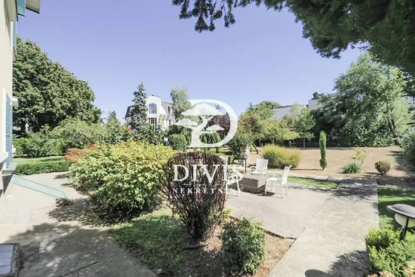 View of the spacious green courtyard with a landscaped garden and outdoor seating furniture.
