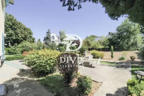 View of the spacious green courtyard with a landscaped garden and outdoor seating furniture. - image 19