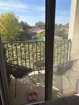 Manji namešteni balkon sa stolicama, stočićem i pogledom na naselje. - image 13