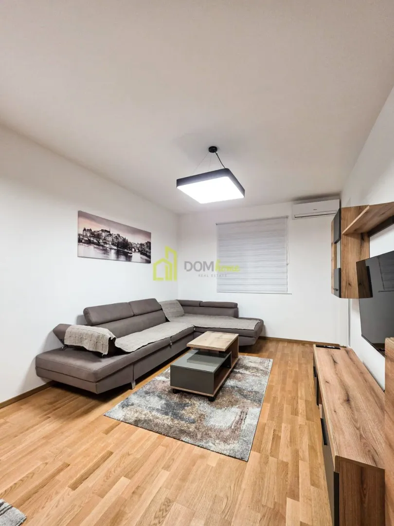 Living room with a sectional sofa, coffee table and TV unit.