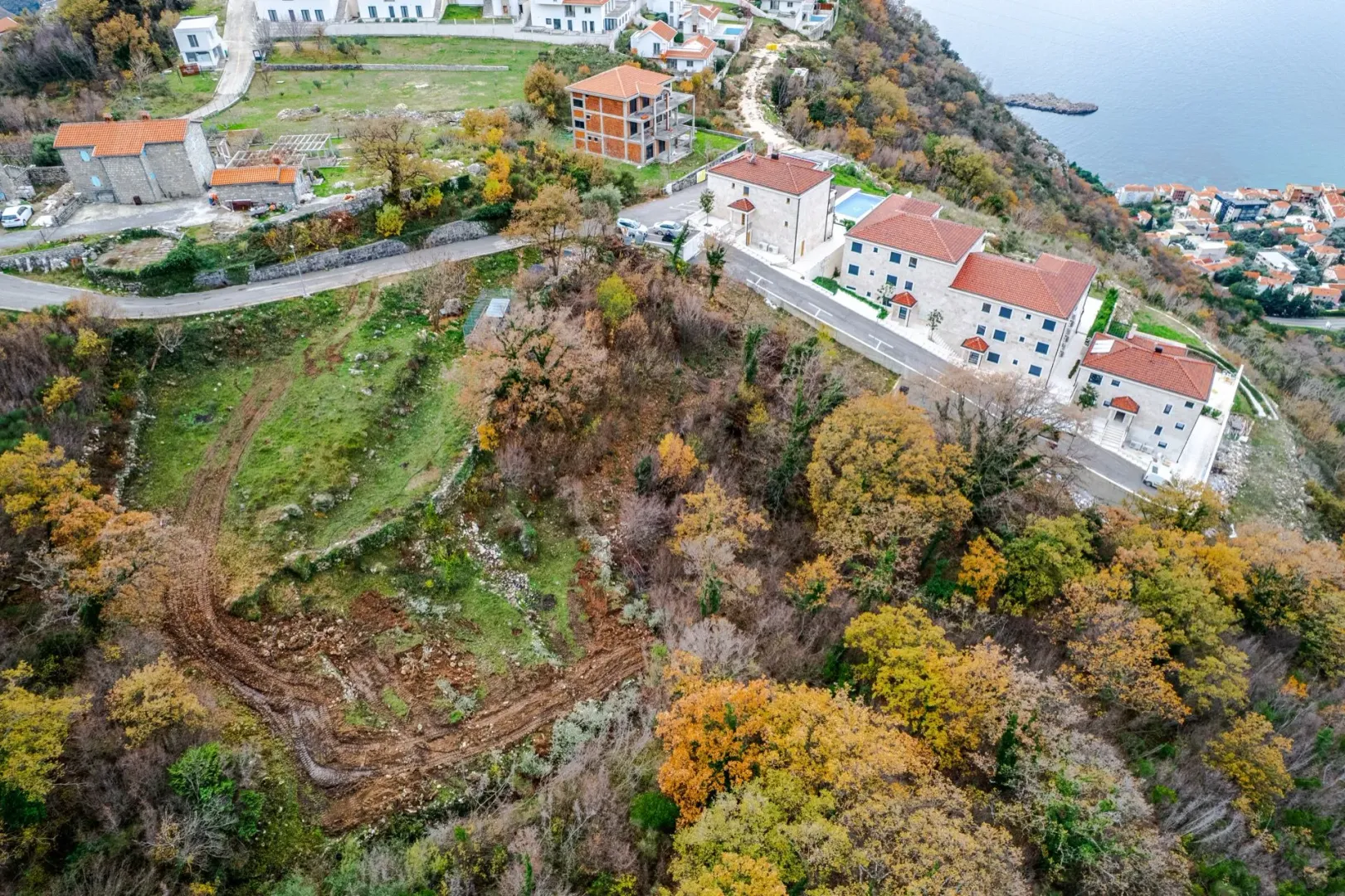 Pogled iz vazduha na kompleks kuća i ok okolni teren.
