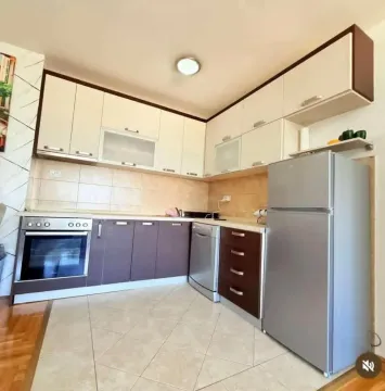 Equipped kitchen with white and brown cabinets and appliances. - image 3
