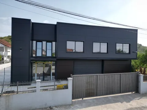 Exterior view of a modern dark-façade commercial or residential building with a fence. - image 3