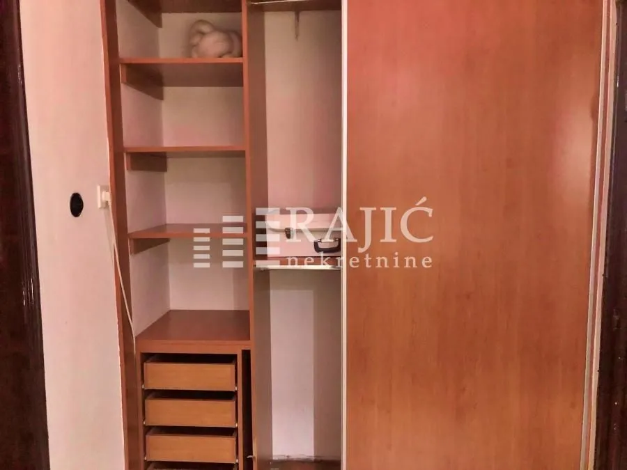 Built-in wardrobe with shelves and drawers in the room.