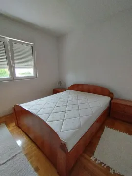 Jednostavno namještena spavaća soba sa drvenim krevetom i noćnim ormarićima. - image 12