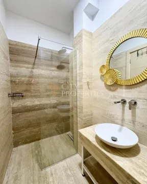 Moderne kupatilo sa tuš kabinom i umivaonikom obloženo kamenim pločicama. - image 10