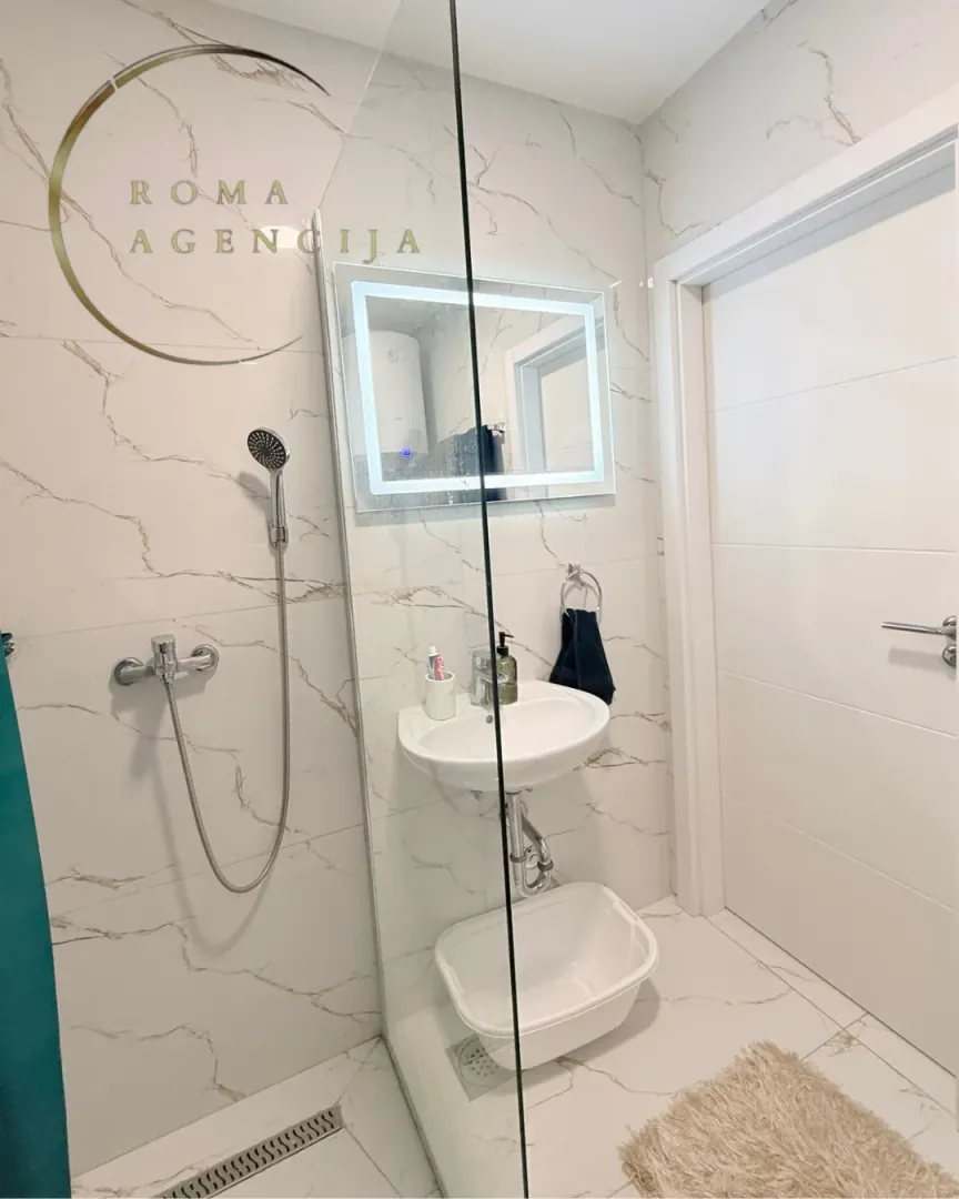 Modernly equipped bathroom with a walk-in shower and washbasin.