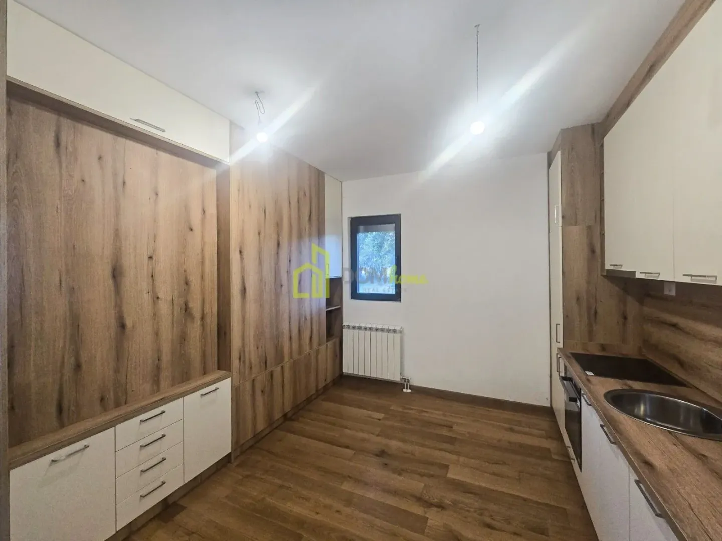 Moderna kuhinja sa drvenim elementima i ugradnim uređajima.