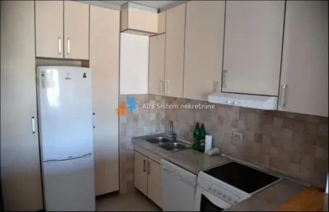 Small kitchen with white cabinets, refrigerator, and kitchen appliances. - image 6
