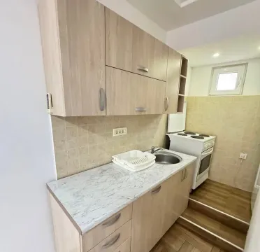 Small kitchen with wooden cabinets and a stove. - image 5