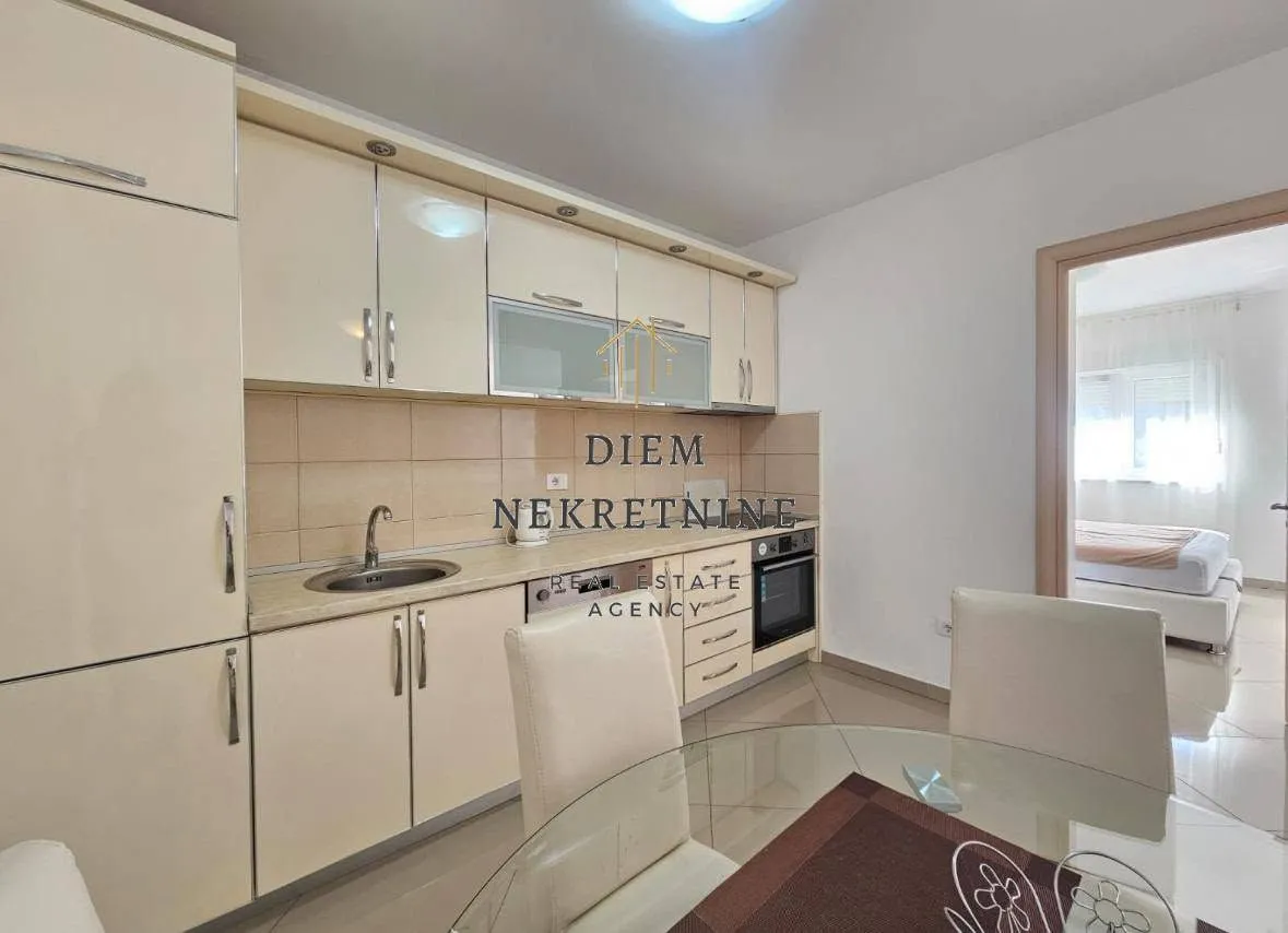 Small kitchen with light-colored cabinets and a dining table.