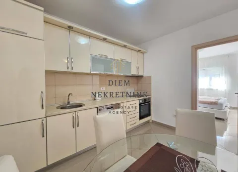Small kitchen with light-colored cabinets and a dining table. - image 8