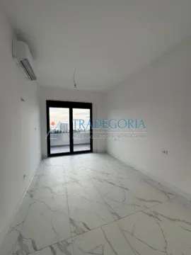Prazna neopremljena prostorija sa bijelim pločicama i izlazom na terasu. - image 6