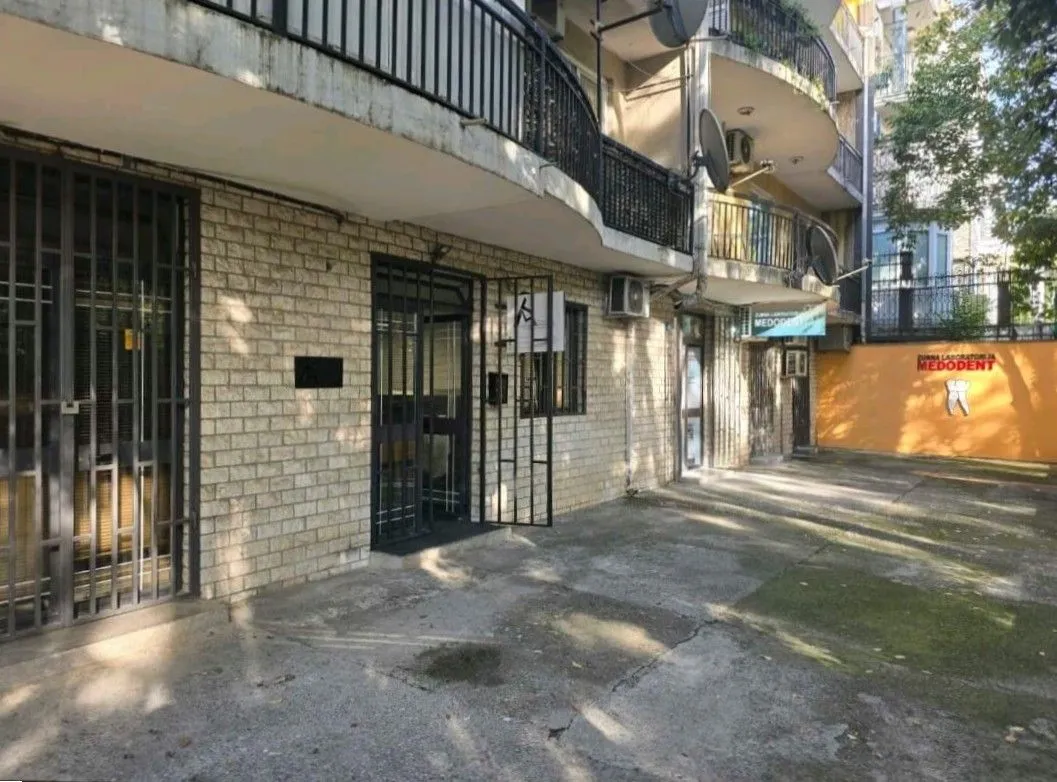 Exterior of the ground floor commercial space in a building with a paved courtyard.