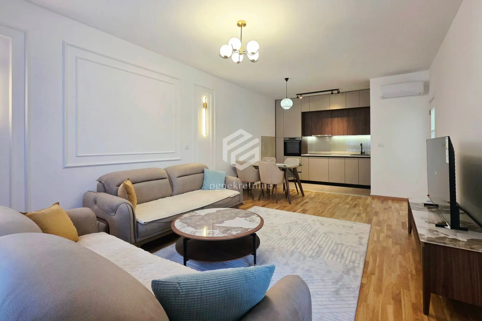 Living room with a sofa set and dining area as part of an open-plan space with the kitchen.
