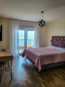Bedroom with a double bed and access to a terrace with a sea view. - image 8