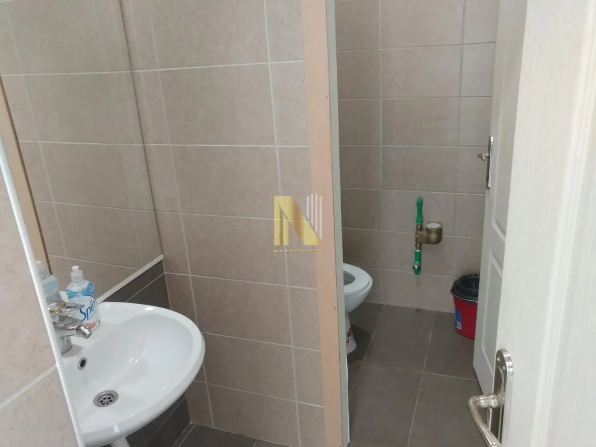 Smaller bathroom tiled with ceramic tiles featuring a sink and toilet.