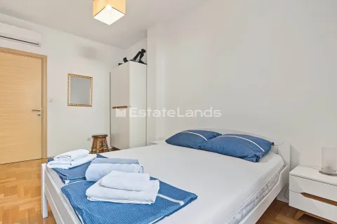 Svijetla spavaća soba sa bračnim krevetom, bijelim ormarom i drvenim podom. - image 11