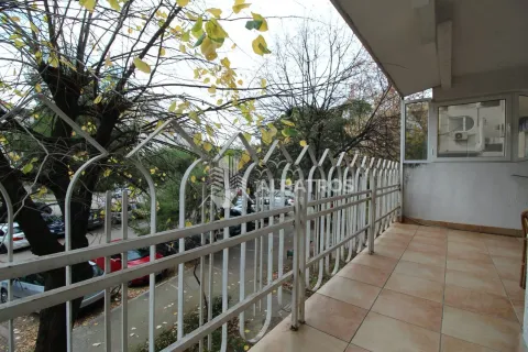 Natkriveni balkon sa popločanim podom i metalnom ogradom, sa pogledom na ulicu i drveće. - image 13