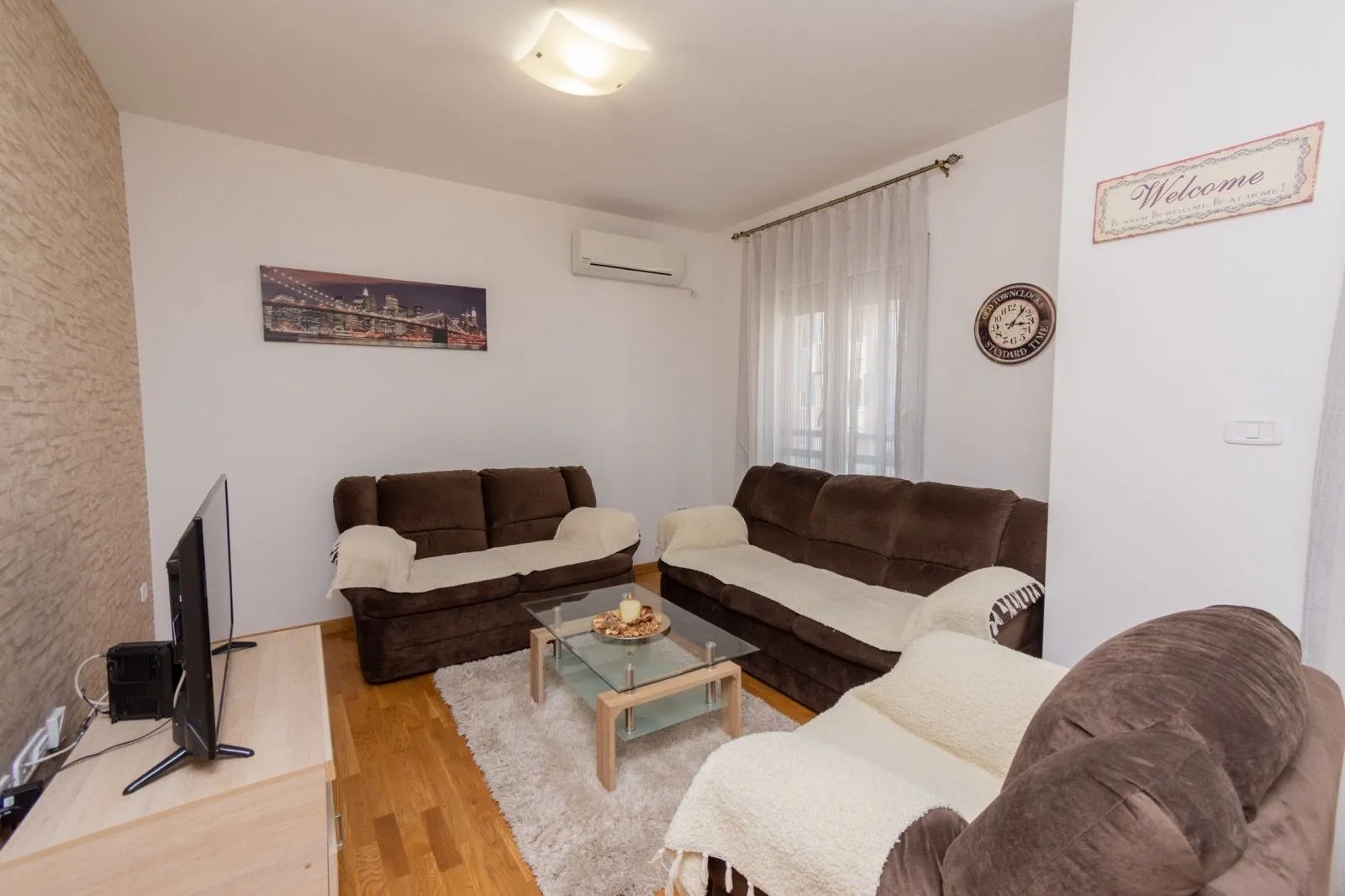 Living room with sofa set, coffee table, and television.