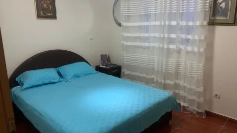 Spavaća soba sa bračnim krevetom i prozorom sa bijelim zavesama. - image 6
