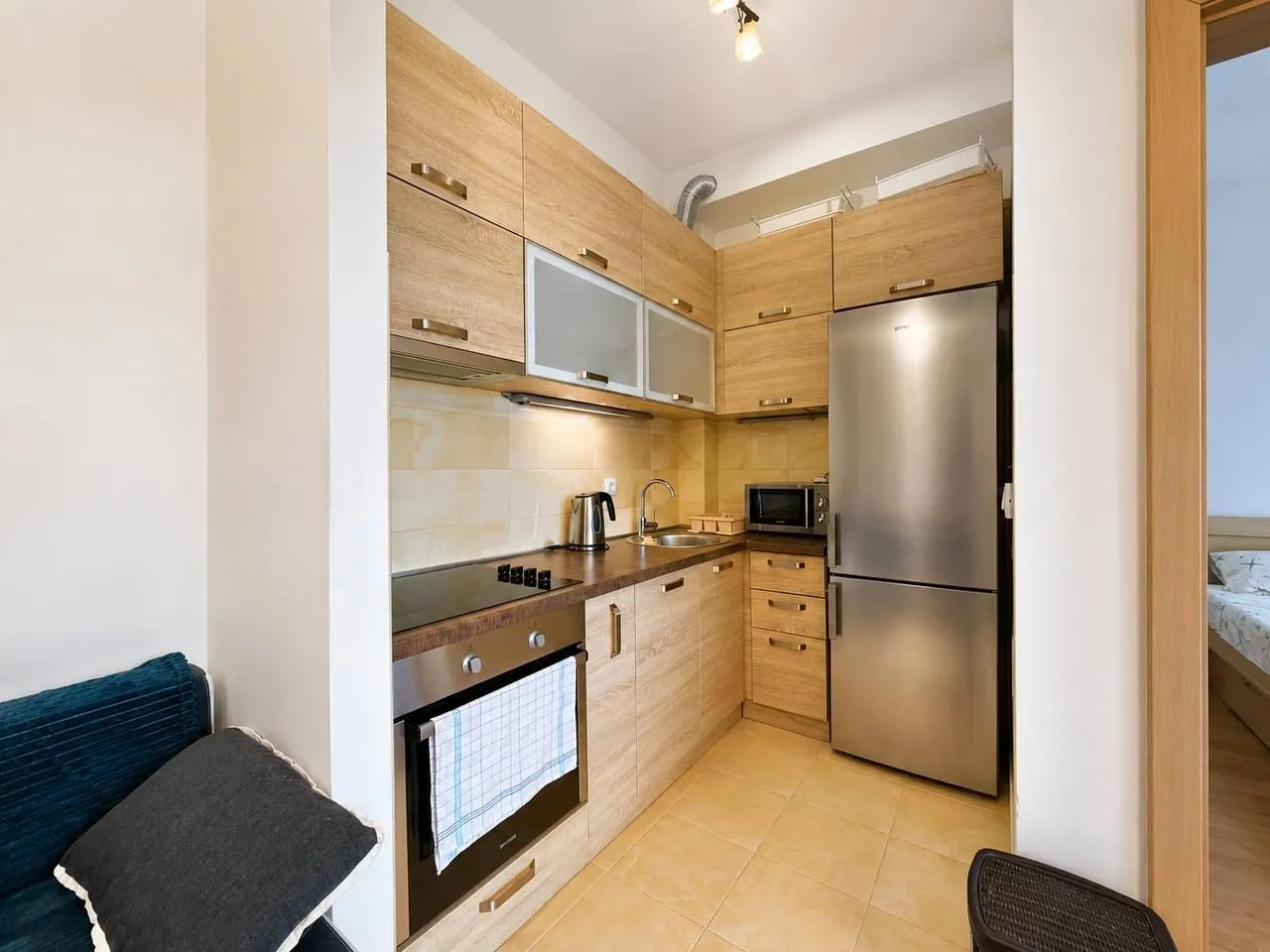 Small kitchen with wooden cabinetry and built-in appliances.