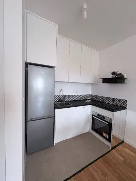 Compact white kitchen with a refrigerator and built-in oven. - image 4