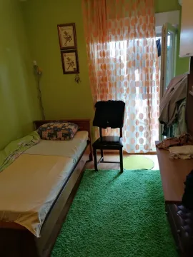 Jednokrevetna spavaća soba sa zelenim zidovima i tepihom. - image 4
