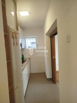 Small white kitchen with a refrigerator and a window. - image 7