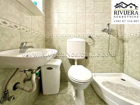 Kupatilo obloženo keramičkim pločicama sa umivaonikom, wc šoljom i tuš kabinom. - image 5