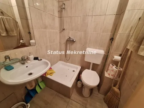 Smaller tiled bathroom with a sink, shower cabin, and toilet. - image 9