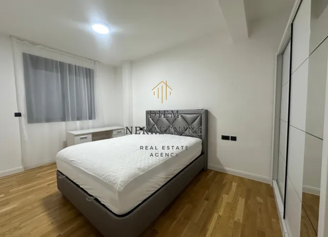 Modern bedroom with a double bed, wardrobe, and desk.