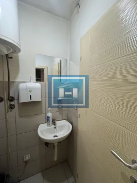 Small bathroom with a sink, water heater, and tiling. - image 8