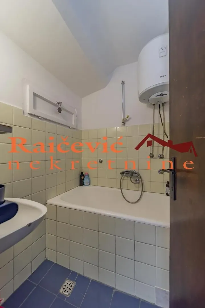 Manje kupatilo sa kadom, umivaonikom i bojlerom.